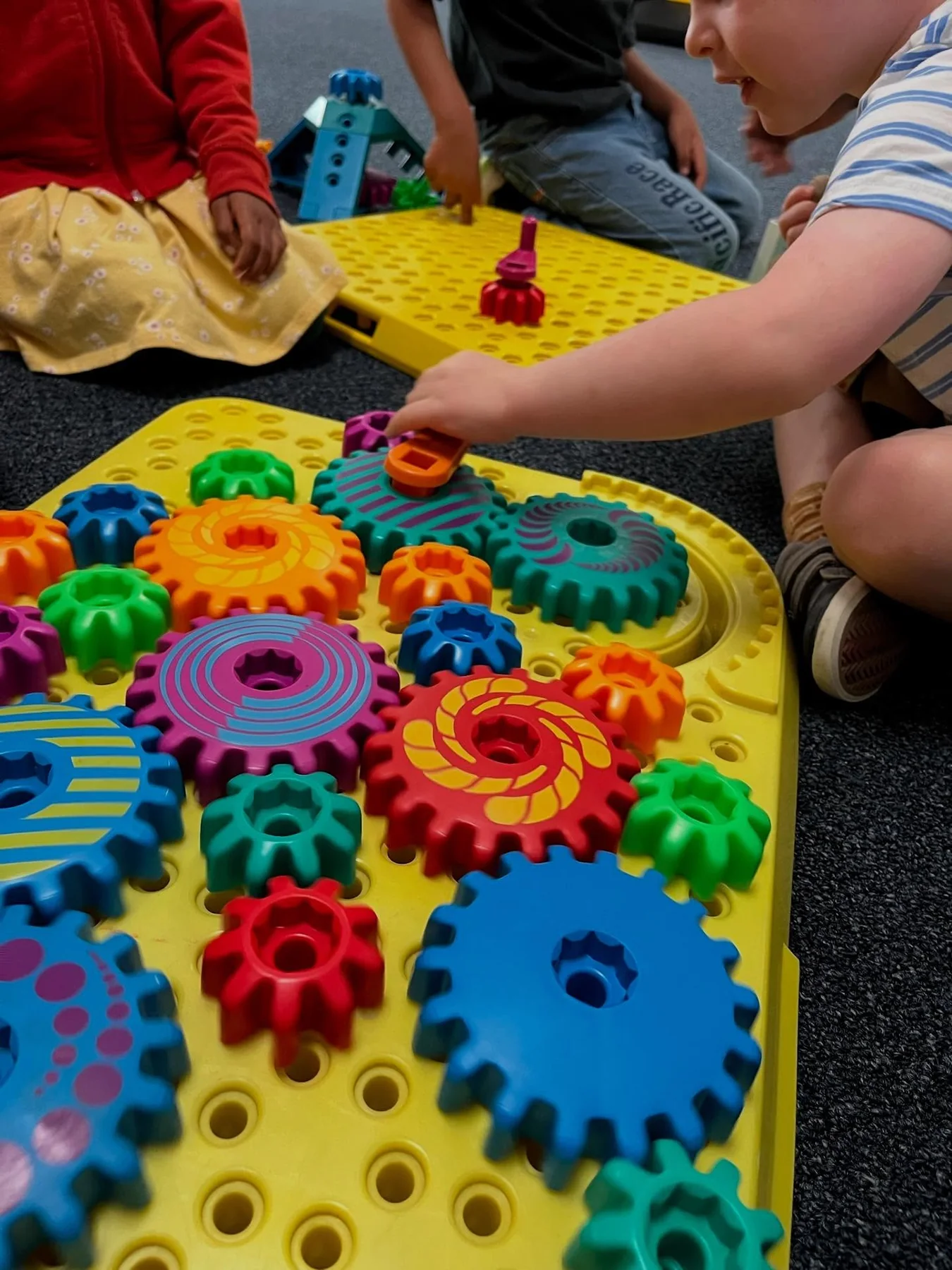 Children exploring colorful gears during a hands-on learning activity