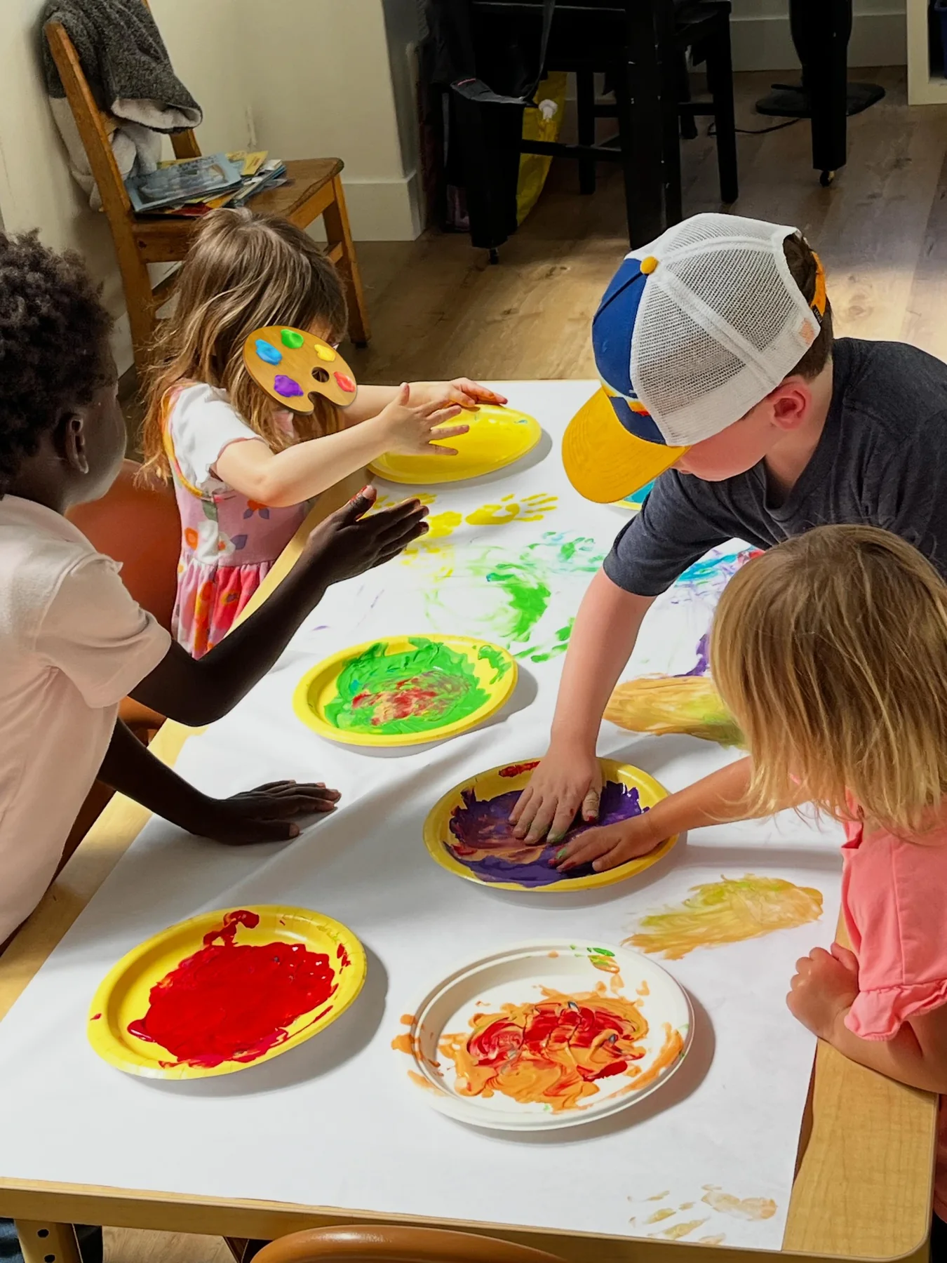 UMC Preschool children creating a colorful group painting together